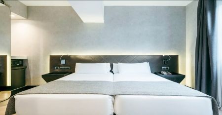 Inngangen til Hotel ILUNION Bel Art Barcelona har store glassd&oslash;rer, potteplanter og et skilt over den svarte markisen - perfekt for gjester som vil utforske Fu&szlig;ballkultur Barcelona eller bes&oslash;ke Trainingseinrichtungen i n&aelig;rheten.