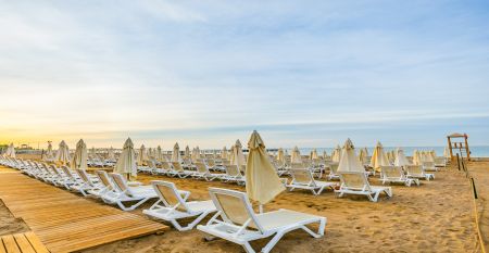 Das Side Moon Palace ist ein modernes Hotel mit mehreren Etagen und Balkonen, von denen aus man den Blick auf einen gro&szlig;z&uuml;gigen Au&szlig;enpool genie&szlig;en kann, der von Reihen wei&szlig;er Liegest&uuml;hle und geschlossenen Sonnenschirmen ges&auml;umt ist.