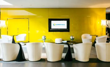 Inngangen til Hotel ILUNION Bel Art Barcelona har store glassdører, potteplanter og et skilt over den svarte markisen - perfekt for gjester som vil utforske Fußballkultur Barcelona eller besøke Trainingseinrichtungen i nærheten.