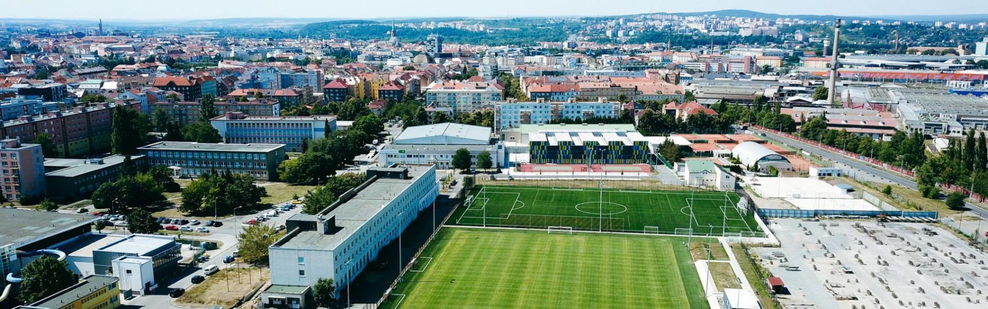 Fu&szlig;balltrainingsanlage in einer Stadtlandschaft, mit mehreren Fu&szlig;ballfeldern und modernen Einrichtungen.