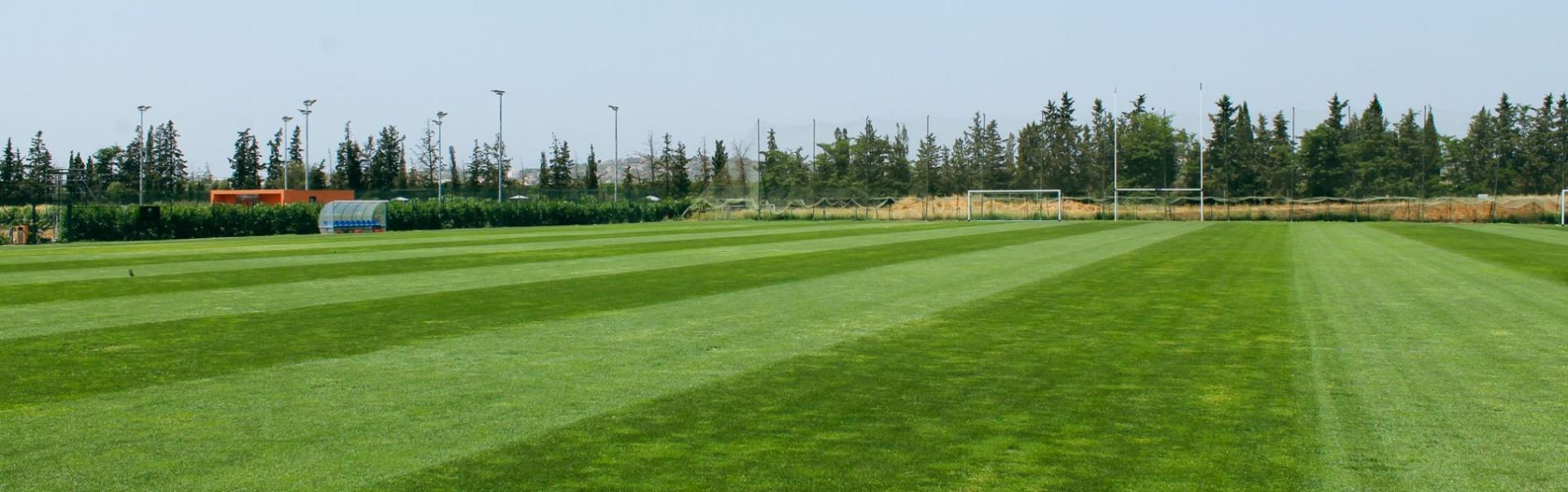 Fu&szlig;ballplatz in Portugal, aufgenommen als Panorama mit sattem Gr&uuml;n und Toren im Hintergrund.