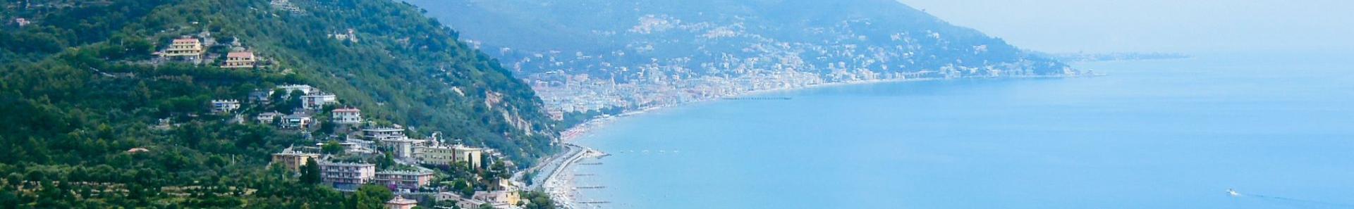 Luftaufnahme der Italienischen Riviera mit Blick auf die K&uuml;ste, die blau schimmernde Bucht und die in die gr&uuml;nen Bergh&auml;nge eingebettete Stadt.