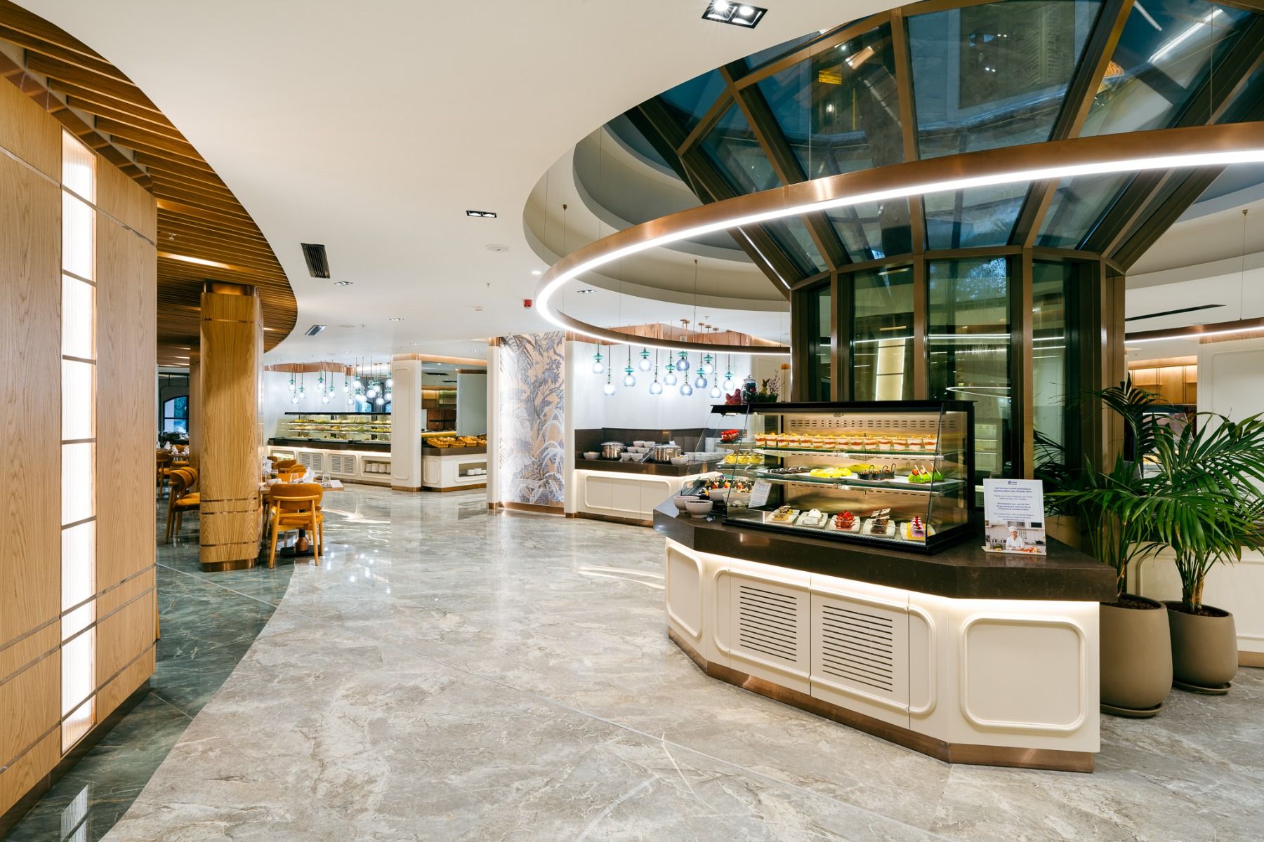 Das Hotel Limak Arcadia verfügt über ein modernes, geräumiges Buffet mit Marmorböden, hölzernen Akzenten, einer gewölbten Decke und gut beleuchteten Auslagen mit Gebäck und Desserts - ideal für Gäste während ihres Fußballtrainingslagers Türkei.