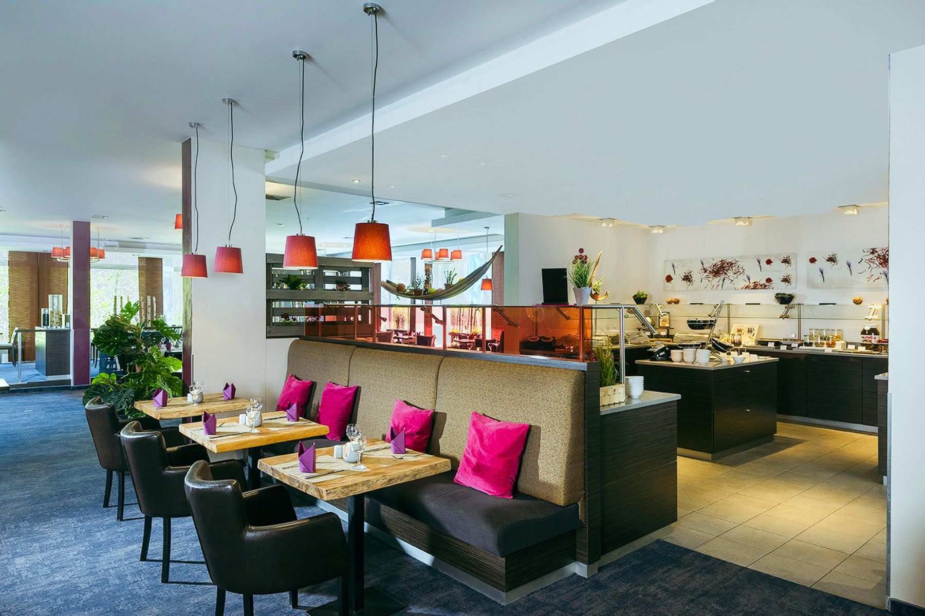 Opplev den stilfulle spisesalen på Mercure Hotel, med trebord, mørke stoler og brune polstrede benker som fremheves av knallrosa puter. Pendellamper lyser opp rommet, mens grønne planter og friske hvite vegger skaper en frisk atmosfære. Med sin beliggenhe