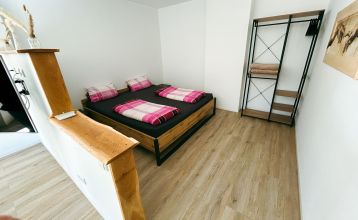 Luftaufnahme des von Bäumen umgebenen Sportparks Fun4You mit großem Solargebäude, Spielplatz, Teambuilding-Seilgarten, Sportplätzen, Parkplatz und bewaldeter Umgebung.