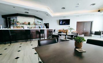 Ein hohes, gelbes Hotel Sol Guadalmar mit Balkonen blickt auf einen klaren, blauen Außenpool, umgeben von Palmen und grünen Rasenflächen unter einem sonnigen Himmel - perfekt für Ihren Aufenthalt in diesem zentrumsnahen 4 Sterne Hotel Malaga.