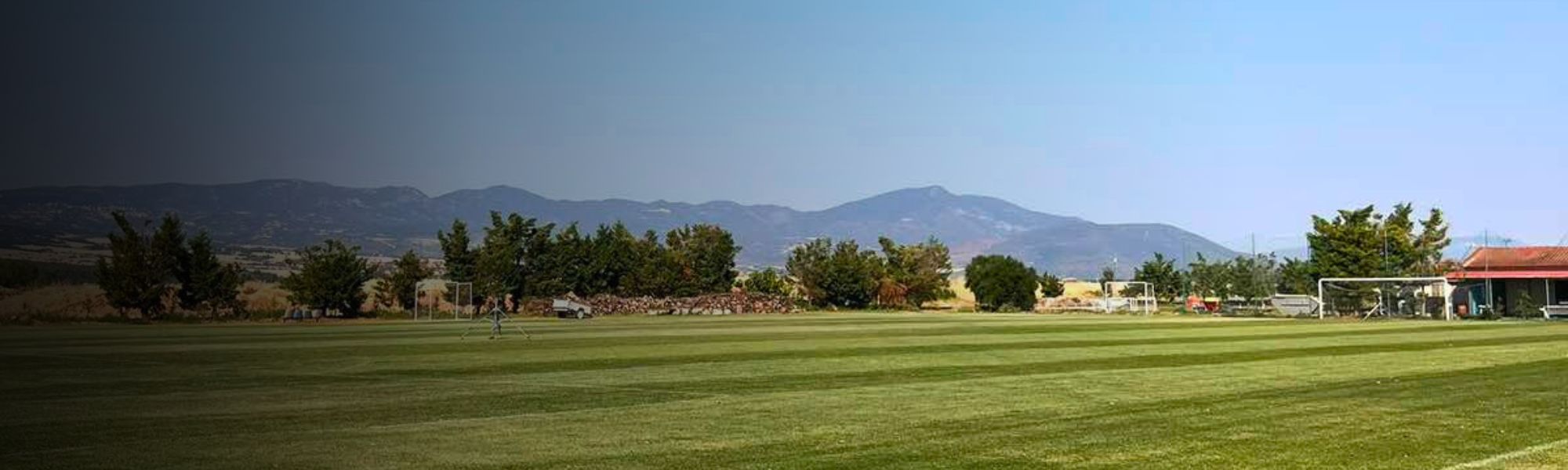 Panoramaaufnahme des Fußballplatzes in Mellieħa mit angrenzenden Wohnhäusern – perfekte Trainingsbedingungen in einer sonnigen Küstenstadt.