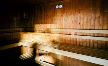 Hotel De Beyaerd’s bright, modern restaurant features large glass walls, light wood floors, and stylish gray and yellow chairs—an ideal setting for teambuilding activities surrounded by lush greenery.