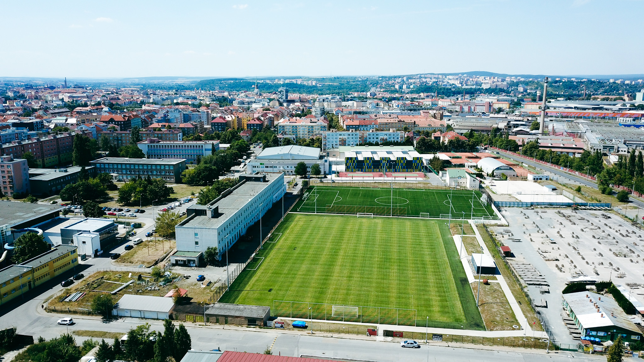 Football training facility in an urban landscape, with several football pitches and modern facilities.
