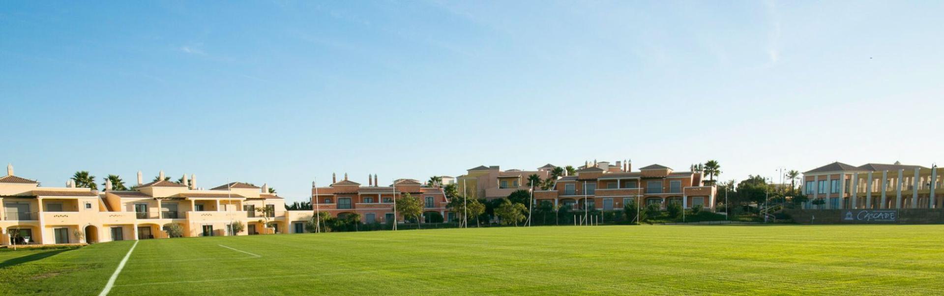 Voetbalveld in de Algarve met directe toegang tot het hotel en palmbomen op de achtergrond.