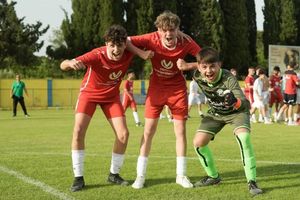 Juichende jeugdspelers in rode tenue tijdens het SOCCACUP voetbaltoernooi