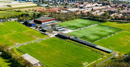 Duinrell is een modern huis van twee verdiepingen met een metalen dak, grote ramen en een houten buitenkant in de buurt van sportinfrastructuur. Geniet van een overdekte patio met buiteneten en meubilair op een verzorgd gazon omringd door bomen onder de b