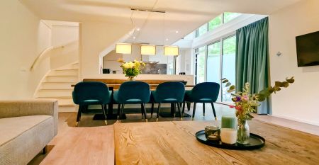 Duinrell is een modern huis van twee verdiepingen met een metalen dak, grote ramen en een houten buitenkant in de buurt van sportinfrastructuur. Geniet van een overdekte patio met buiteneten en meubilair op een verzorgd gazon omringd door bomen onder de b