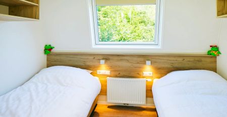 Duinrell is een modern huis van twee verdiepingen met een metalen dak, grote ramen en een houten buitenkant in de buurt van sportinfrastructuur. Geniet van een overdekte patio met buiteneten en meubilair op een verzorgd gazon omringd door bomen onder de b