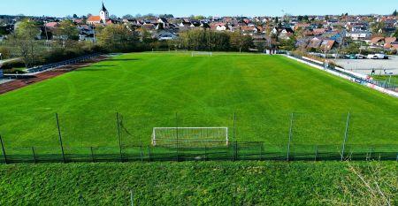 Hotel Empfinger Hof, med r&oslash;dt tegltak og kvistevinduer, &oslash;nsker gjester velkommen til Fu&szlig;balltrainingslager. Et "Hotel Restaurant"-skilt kroner bygningen, med tr&aelig;r og en asfaltert inngang som tilbyr gute Verpflegung og solrik varme.