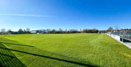 Hotel Empfinger Hof, med r&oslash;dt tegltak og kvistevinduer, &oslash;nsker gjester velkommen til Fu&szlig;balltrainingslager. Et "Hotel Restaurant"-skilt kroner bygningen, med tr&aelig;r og en asfaltert inngang som tilbyr gute Verpflegung og solrik varme.