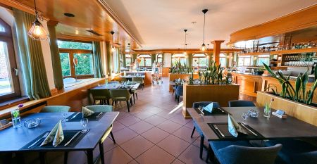 Hotel Empfinger Hof, med r&oslash;dt tegltak og kvistevinduer, &oslash;nsker gjester velkommen til Fu&szlig;balltrainingslager. Et "Hotel Restaurant"-skilt kroner bygningen, med tr&aelig;r og en asfaltert inngang som tilbyr gute Verpflegung og solrik varme.