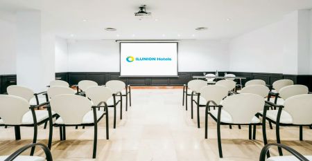 Inngangen til Hotel ILUNION Bel Art Barcelona har store glassdører, potteplanter og et skilt over den svarte markisen - perfekt for gjester som vil utforske Fußballkultur Barcelona eller besøke Trainingseinrichtungen i nærheten.