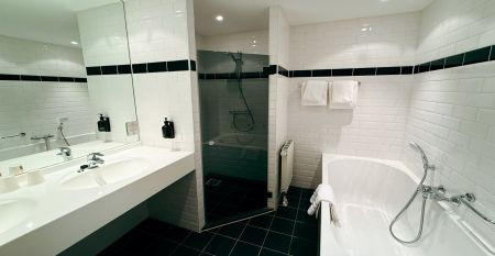 Hotel De Beyaerd biedt een ruim, modern restaurant met grote glazen ramen, lichthouten tafels, grijze en mosterdkleurige stoelen, hangende potplanten en uitzicht op bomen - ideaal voor teambuildingsactiviteiten.