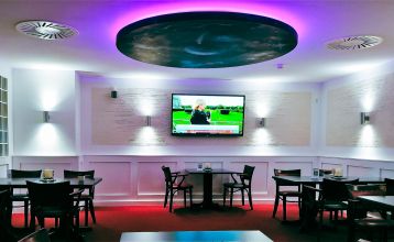Hotel Stadt Mühlhausen*** is een groot, modern, grijs-wit gebouw met ronde ramen, een bord boven de ingang, bomen in de buurt, een bewolkte hemel en een eigen fitnessruimte voor het comfort van de gasten.