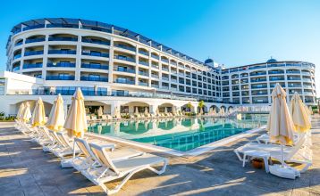 Het Side Moon Palace is een modern hotel met meerdere verdiepingen en balkons vanwaar gasten kunnen genieten van het uitzicht op een ruim buitenzwembad, omringd door rijen witte ligstoelen en gesloten parasols.