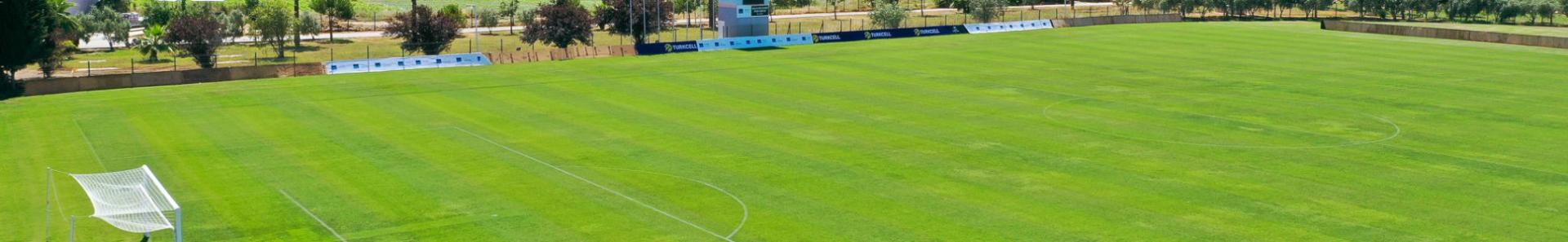  Fotballbane i Side med gr&oslash;nne omgivelser, perfekt spilleflate og en imponerende mosk&eacute; i bakgrunnen.