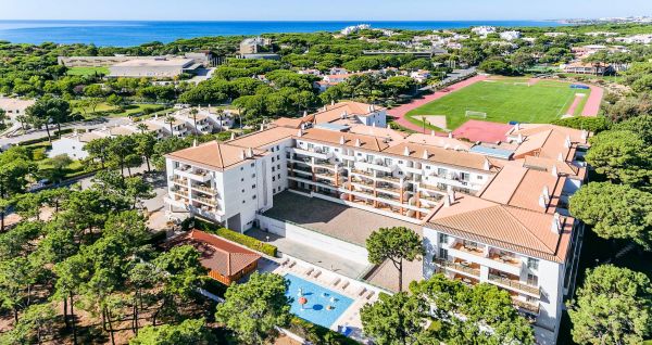 Luftfoto av Victoria Sports & Beach Hotel, et moderne ferieanlegg med svømmebasseng, omgitt av furutrær i Albufeira, i nærheten av idrettsbaner for fotballtreningsleirer og ikke langt fra den solfylte kysten.
