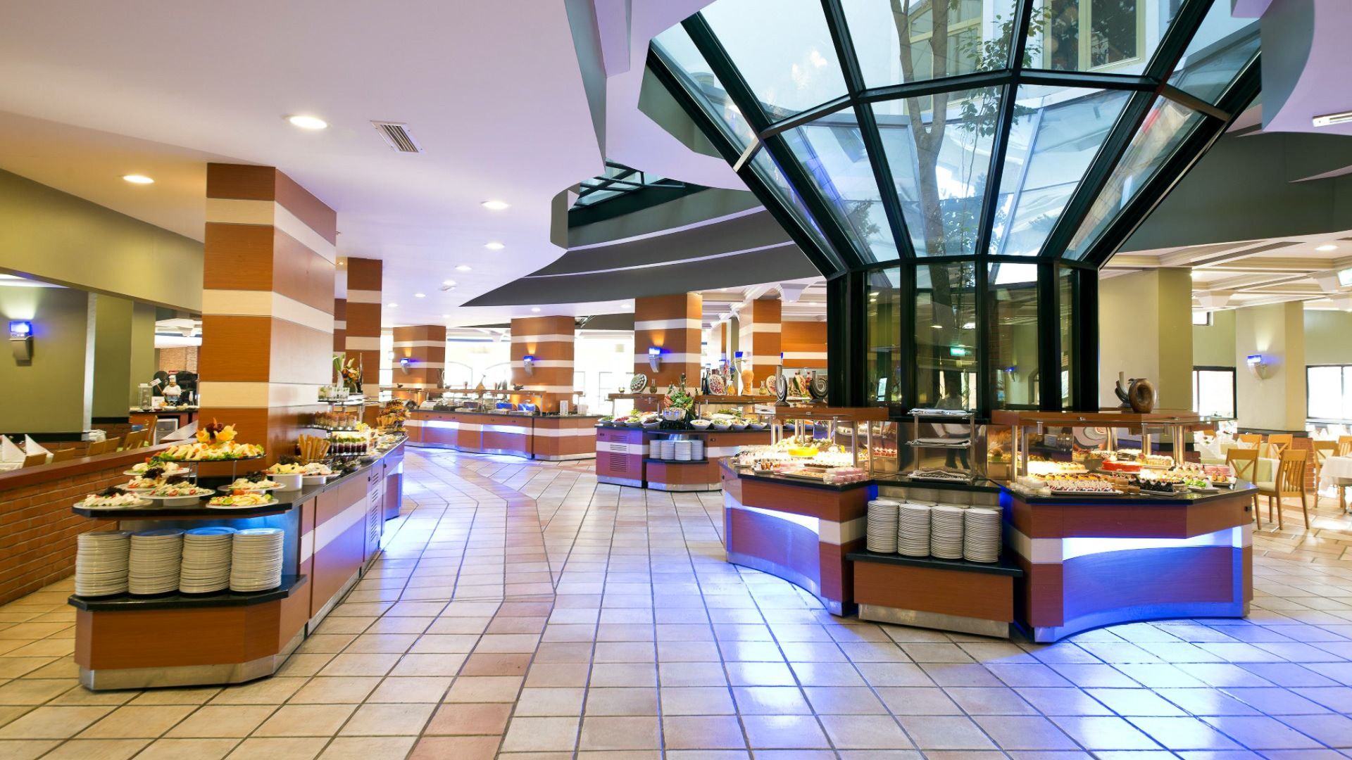 Limak Arcadia Hotel tilbyr en romslig og moderne buffé med ulike matstasjoner, pent oppstilte bord og lyse rom - ideelt for gjester under oppussingsarbeid eller fotballtreningsleirer i Tyrkia.