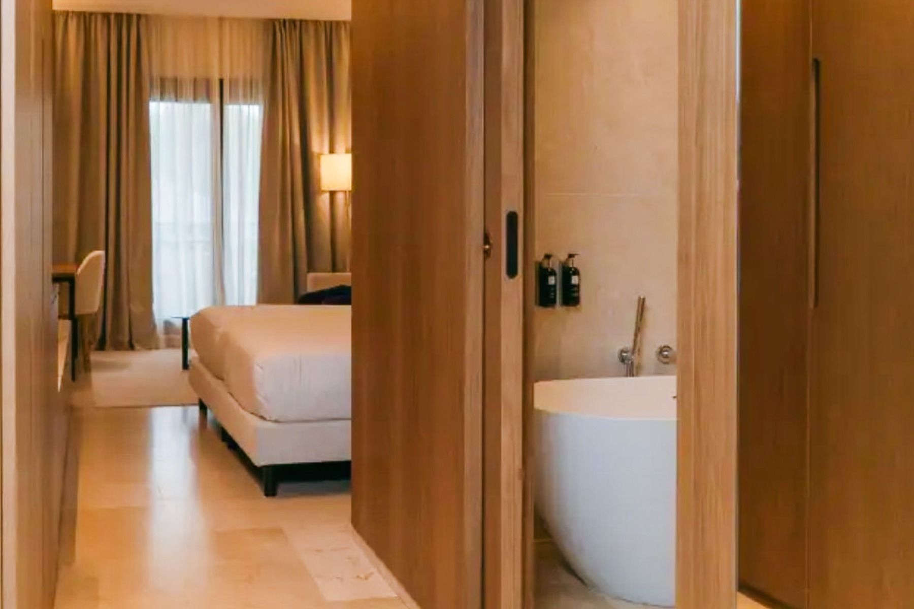 Et rom på Hotel SH Villa Gadea* har et moderne bad med frittstående badekar, en seng, et skrivebord og vinduer fra gulv til tak – perfekt for å slappe av etter en treningsøkt i de nærliggende idrettsanleggene eller på treningsleiren i Altea.