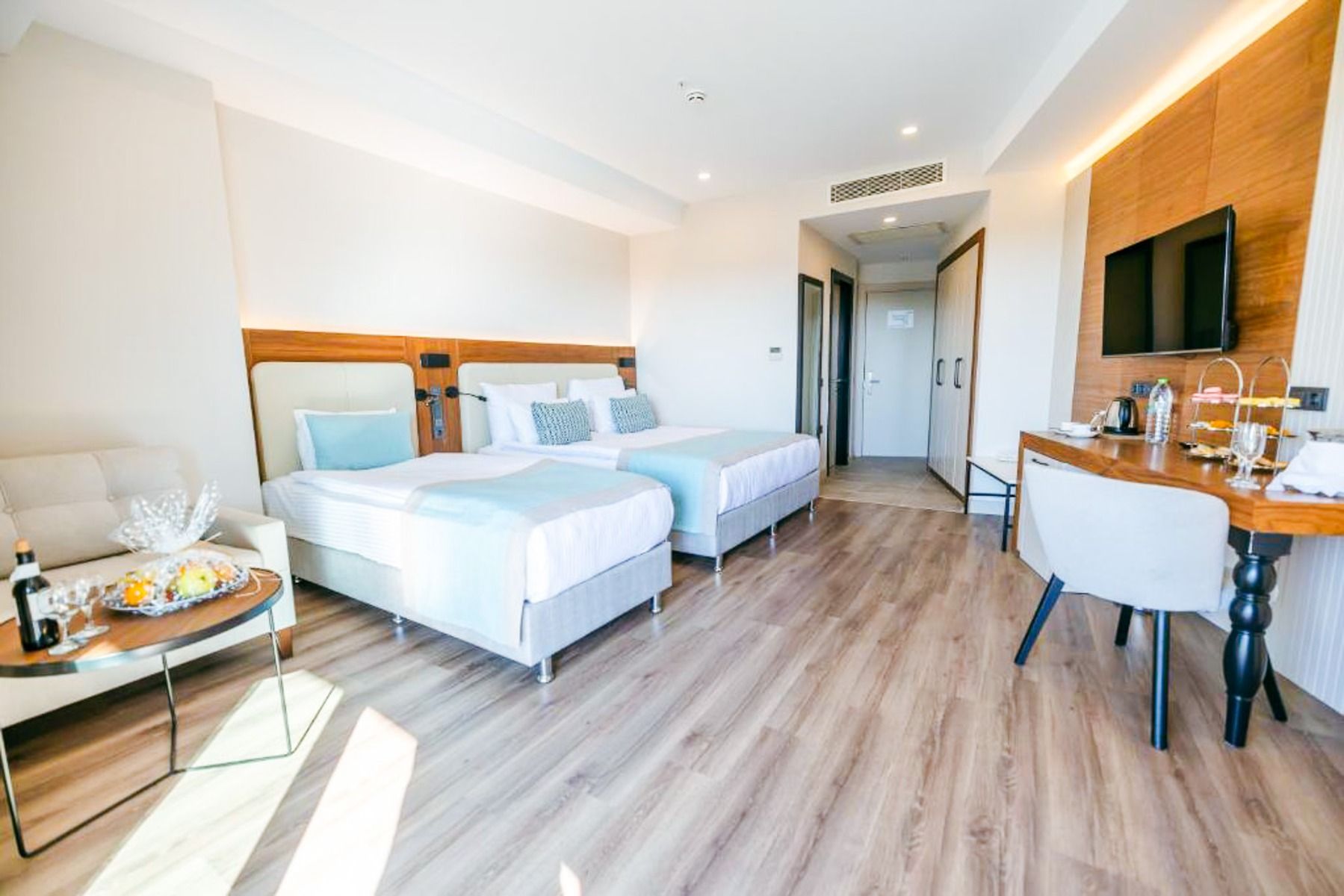 Side Moon Palace tilbyr et lyst og moderne rom med to senger, sengetøy i lyse farger, et skrivebord og en stol, en flatskjerm-TV, en minibar, en lenestol med et brett for snacks og drikke, samt tregulv.