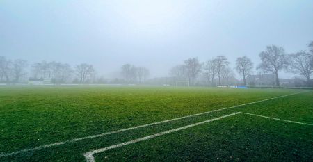 Das Sporthotel Bruurs ist ein modernes zweistöckiges Gebäude mit gelben Dächern und Wellness-Schildern, umgeben von grünen Hecken und Bäumen in Baarle-Nassau unter einem teilweise bewölkten Himmel - ideal für ein Trainingslager.