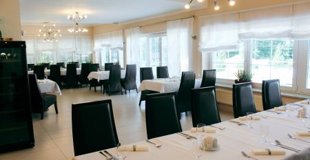 Luftaufnahme des Parkhotels mit Sonnenkollektoren, Au&szlig;enpool, Tennispl&auml;tzen, Fitnessstudio und gro&szlig;em Parkplatz inmitten von B&auml;umen nahe dem Stadtzentrum von Pilsen an einem sonnigen Tag.