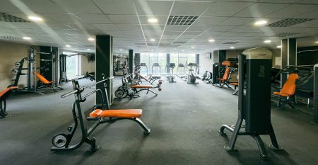 Luftaufnahme des Parkhotels mit Sonnenkollektoren, Au&szlig;enpool, Tennispl&auml;tzen, Fitnessstudio und gro&szlig;em Parkplatz inmitten von B&auml;umen nahe dem Stadtzentrum von Pilsen an einem sonnigen Tag.