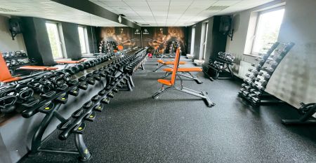 Luftaufnahme des Parkhotels mit Sonnenkollektoren, Au&szlig;enpool, Tennispl&auml;tzen, Fitnessstudio und gro&szlig;em Parkplatz inmitten von B&auml;umen nahe dem Stadtzentrum von Pilsen an einem sonnigen Tag.