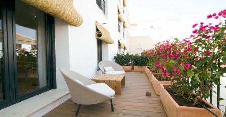 G&aring;rdsplassen p&aring; Hotel Zenit Sevilla har palmer, uteservering og potteplanter. Omgitt av hvite bygninger - en av dem med "GOOD NIGHT" p&aring; taket - er det et avslappende sted for Fu&szlig;ball-Sportgruppen. P&aring; skiltet st&aring;r det "Zenit Hotels".