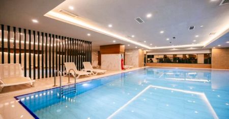 Side Moon Palace er et moderne hotell med flere etasjer og balkonger, hvor gjestene kan nyte utsikten over et romslig utend&oslash;rsbasseng omgitt av rekker med hvite solsenger og sammenfoldede parasoller.