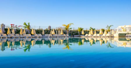 Side Moon Palace er et moderne hotell med flere etasjer og balkonger, hvor gjestene kan nyte utsikten over et romslig utend&oslash;rsbasseng omgitt av rekker med hvite solsenger og sammenfoldede parasoller.