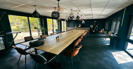 Luftaufnahme des Watersley Sports & Talentpark, eines weitläufigen historischen Komplexes mit grauem Dach, eingebettet in eine grüne Landschaft. Der Campus umfasst ein kapellenartiges Gebäude, erstklassige Trainingseinrichtungen und bietet einen Blick auf