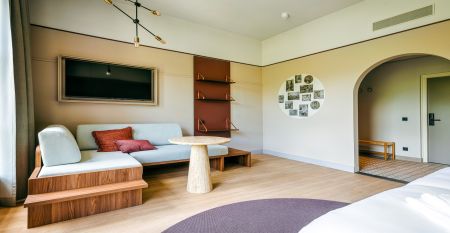 Luftaufnahme des Watersley Sports & Talentpark, eines weitläufigen historischen Komplexes mit grauem Dach, eingebettet in eine grüne Landschaft. Der Campus umfasst ein kapellenartiges Gebäude, erstklassige Trainingseinrichtungen und bietet einen Blick auf