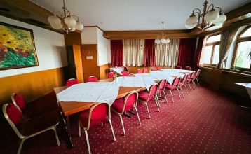 Hotel Empfinger Hof, med rødt tegltak og kvistevinduer, ønsker gjester velkommen til Fußballtrainingslager. Et "Hotel Restaurant"-skilt kroner bygningen, med trær og en asfaltert inngang som tilbyr gute Verpflegung og solrik varme.