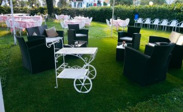 Luftaufnahme des Hotels Everest***, eines rosafarbenen mehrstöckigen Gebäudes mit renovierten Zimmern, umgeben von Grünanlagen, einer kleinen Kirche, Häusern, Gärten, bewaldeten Hügeln und nahe gelegenen Fußball- und Trainingsplätzen, die sich in die frie