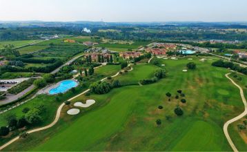 Moderne zweistöckige Appartements Residence Eden*** mit Balkonen und braunen Dächern, eingebettet in grüne Rasenflächen und Sträucher mit gepflasterten Gehwegen unter blauem Himmel - ideal für preisbewusste Mannschaften, die Komfort suchen.