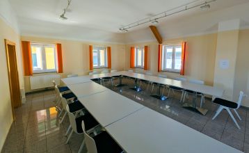 Hotell- og restaurant Schachenwald er en strålende gul, toetasjes bygning med rødt takstein under blå himmel – ideelt for treningsleirer – med potteplanter ved inngangen og biler parkert på den brosteinsbelagte oppkjørselen.
