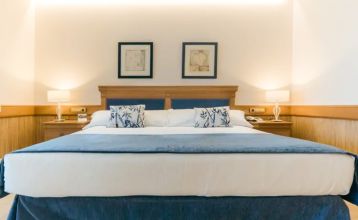 Hotel SH Villa Gadea* er et feriested ved kysten med utsikt over havet, en stor hvit bygning, et svømmebasseng, palmer og grønne plener – ideelt for fotballag under treningsleiren i Altea under en knallblå himmel.