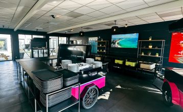 Luftaufnahme des Watersley Sports & Talentpark, eines weitläufigen historischen Komplexes mit grauem Dach, eingebettet in eine grüne Landschaft. Der Campus umfasst ein kapellenartiges Gebäude, erstklassige Trainingseinrichtungen und bietet einen Blick auf