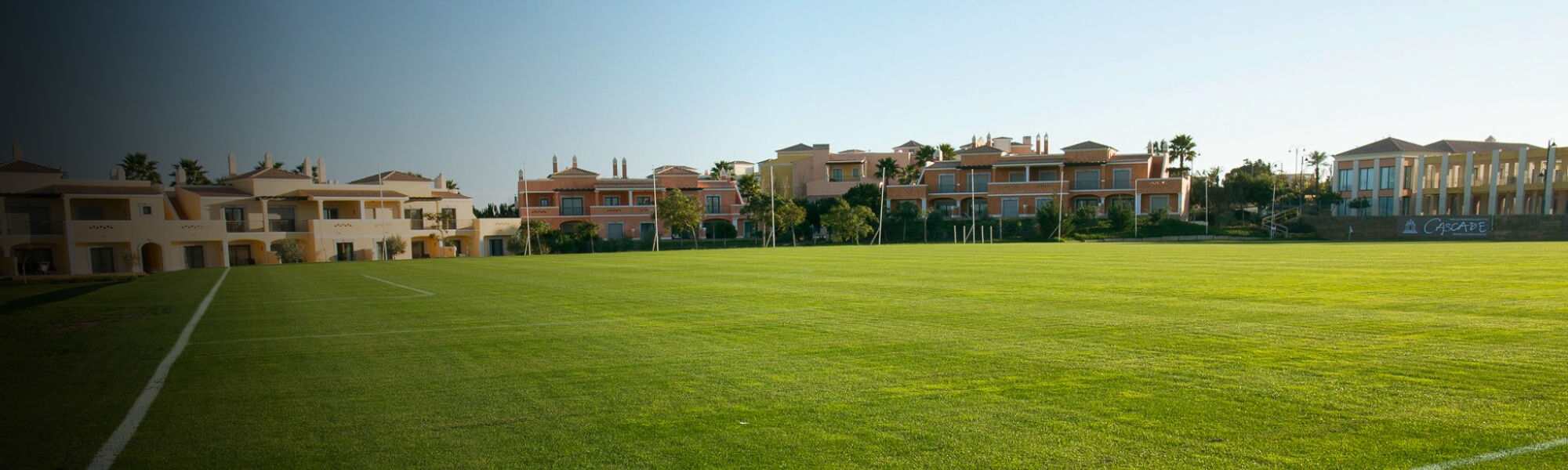 Fu&szlig;ballplatz in der Algarve mit direkter Hotelanbindung und Palmen im Hintergrund.