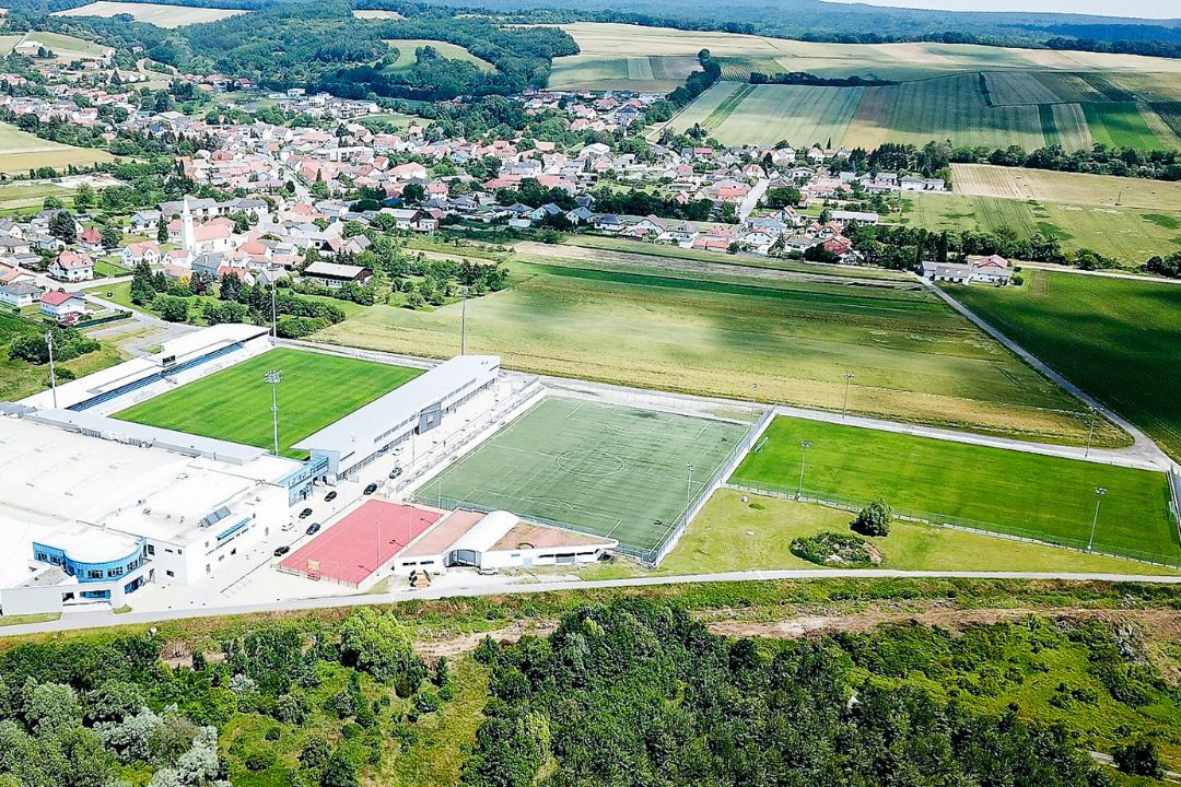 Weitl&auml;ufige Fu&szlig;balltrainingsanlage im Burgenland mit Rasenpl&auml;tzen, Kunstrasenplatz, Sporthalle und umliegenden Feldern in l&auml;ndlicher Idylle.