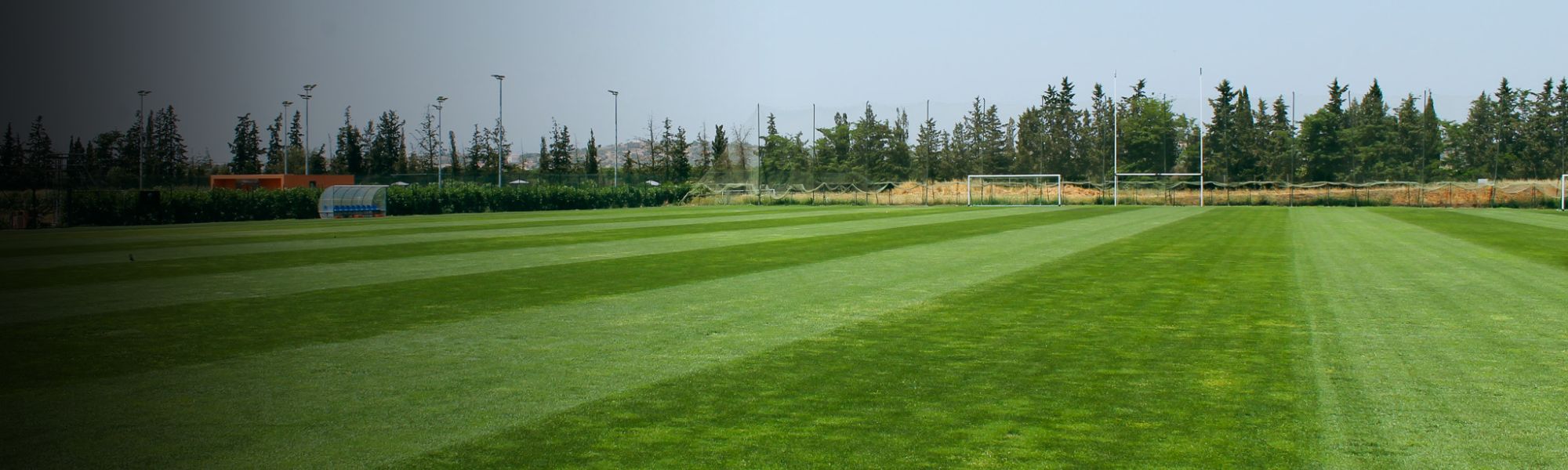 Fu&szlig;ballplatz in Portugal, aufgenommen als Panorama mit sattem Gr&uuml;n und Toren im Hintergrund.